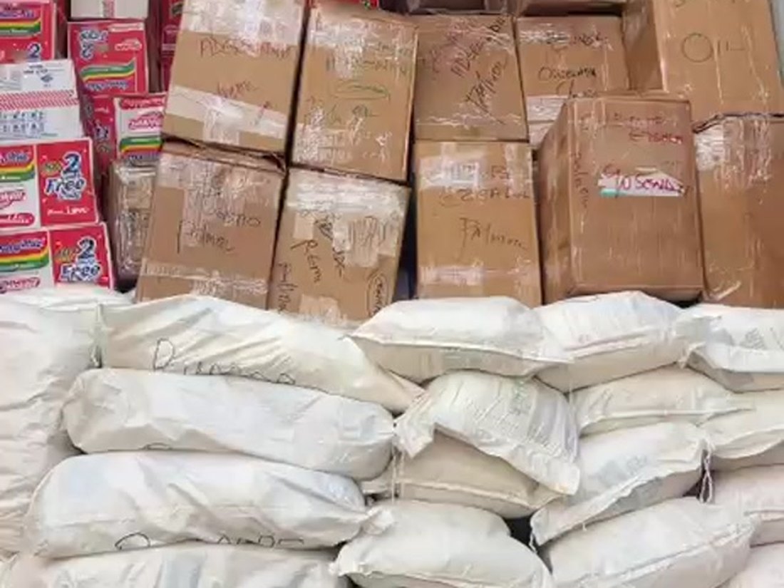 Shipping container loaded floor to ceiling with sacks and cartons of food